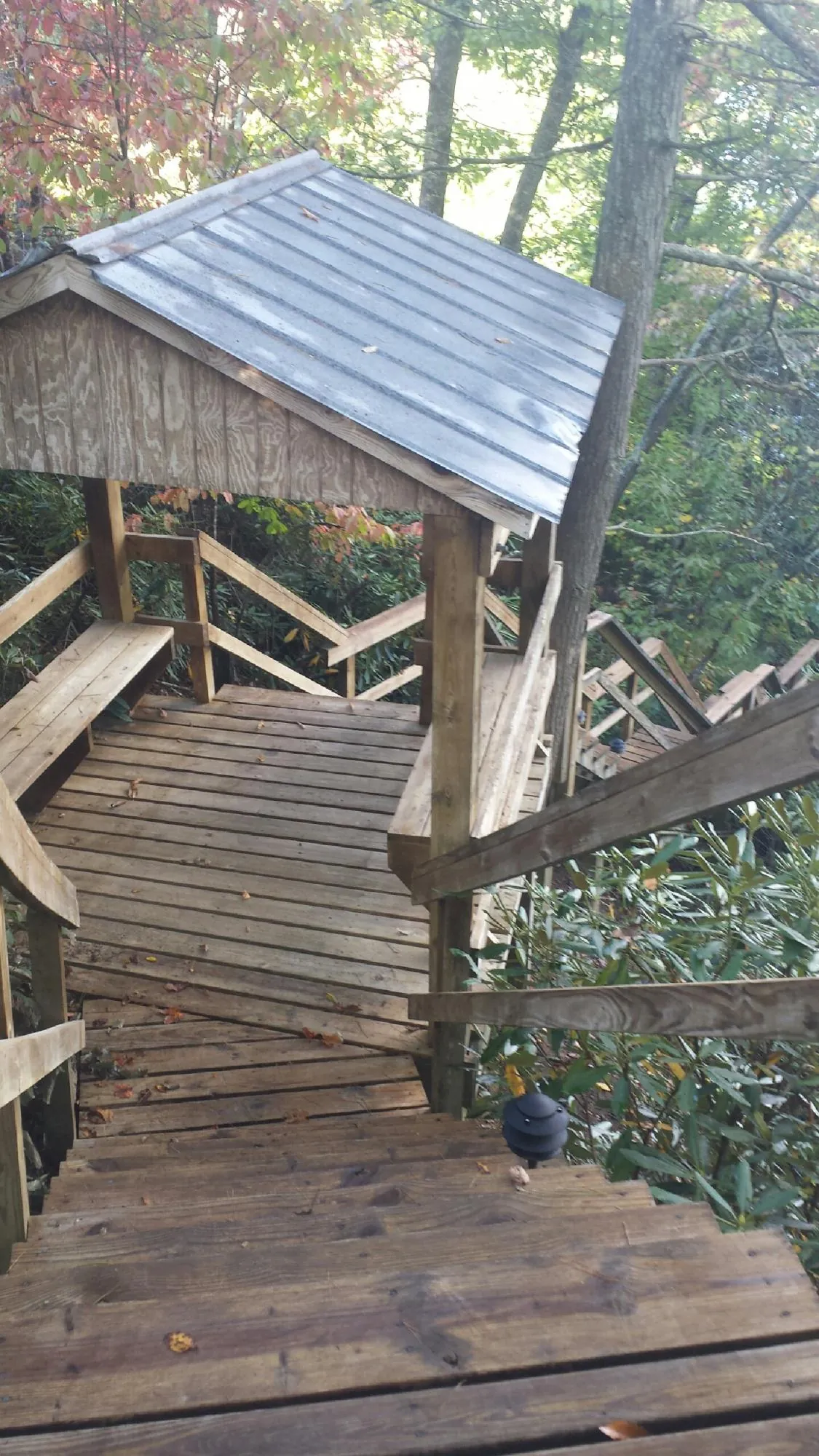 Metal roofed shelter over wooden steps on a wooded walkway — Skylight Repair & Installation work by our crew in Oglesby
