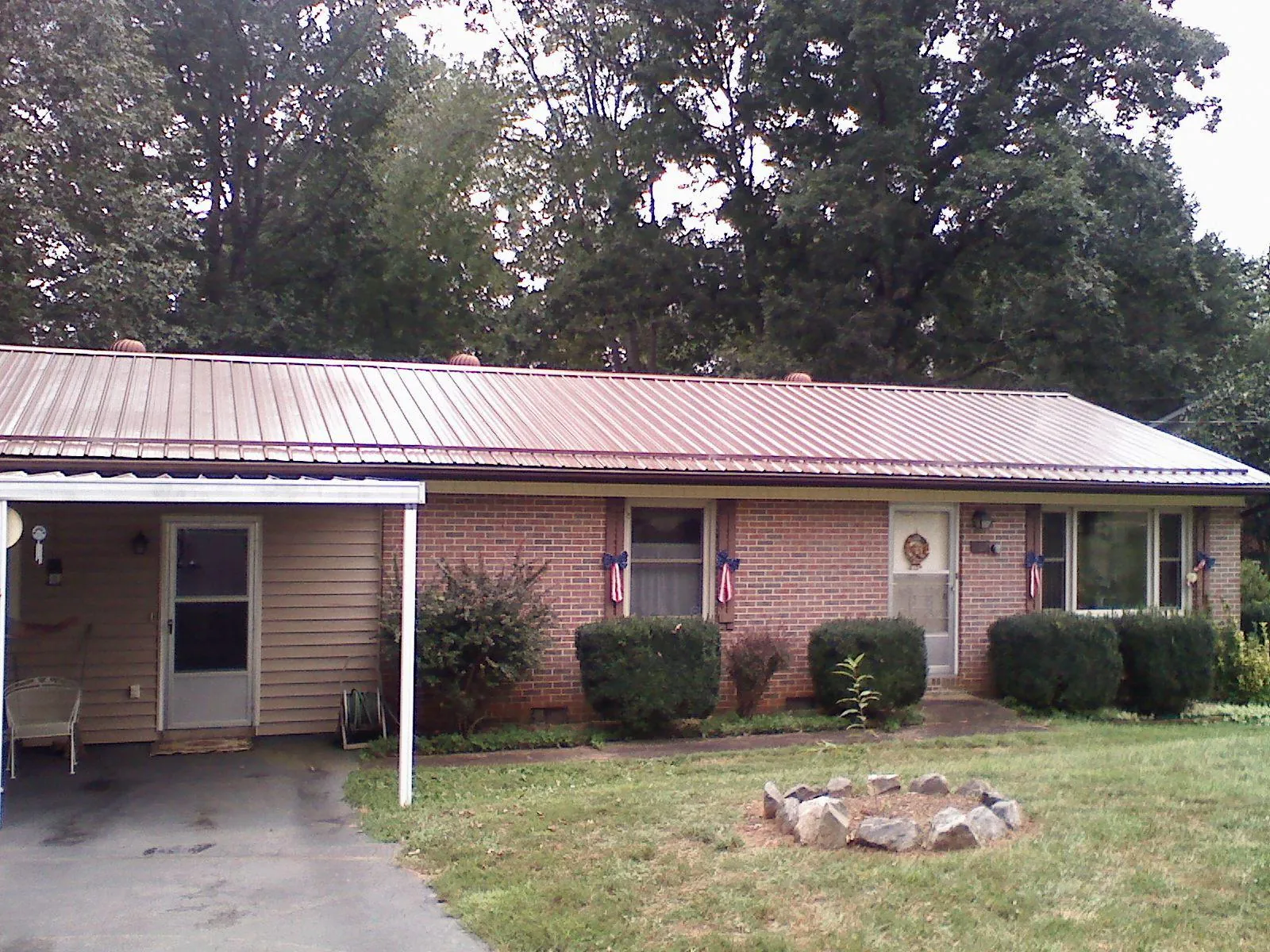 Bronze metal roof and carport on a brick ranch home — Roof Repair work by our crew in Oglesby